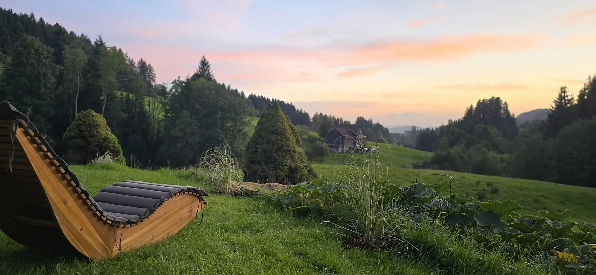 Hölzerne Relaxliege mit Blick über das abendliche Appenzellerland