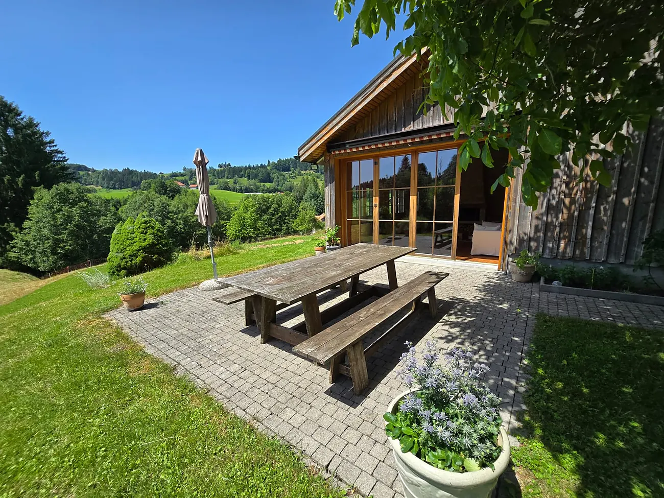 Terrasse mit Holztisch und Blick in den Garten